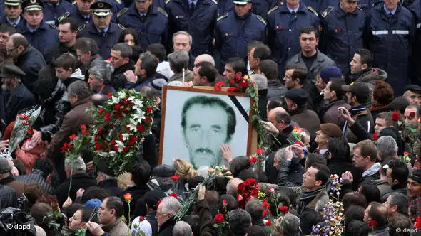 Menschen tragen Rosen und große Fotos durch die Straßen (Foto: AP)