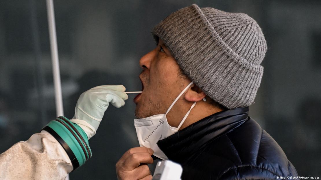 A health worker takes a swab sample from a man to be tested for the COVID at a hospital in Beijing