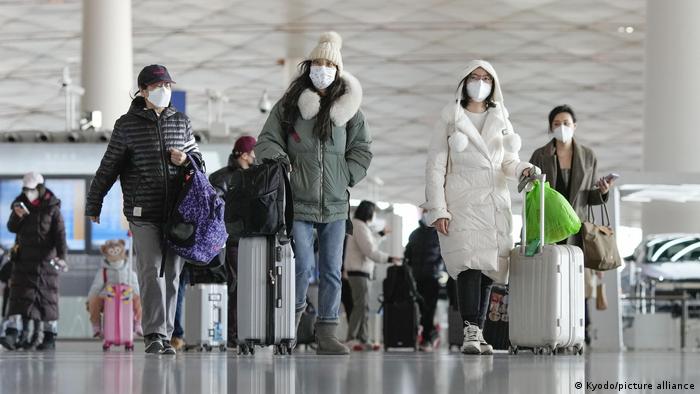 China | Passagiere mit Masken im Flughafen Peking