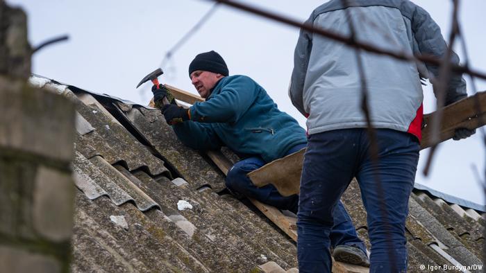 Freiwillige Helfer reparieren das zerstörte Dach eines Hauses