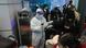 A person in a protective suit stands in an airport as travelers wait to board buses to leave for quarantine in China A person in a protective suit stands in an airport as travelers wait to board buses to leave for quarantine in China
