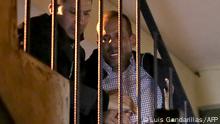 Luis Fernando Camacho (R), a key opposition figure and governor of the economic powerhouse Santa Cruz region, is escorted up a staircase upon arriving at the headquarters of the Special Forces for Fight against Crime (FELCC in Spanish) in La Paz, Bolivia, following his arrest on December 28, 2022. - Bolivian police on Wednesday arrested Luis Fernando Camacho, a key opposition figure and governor of the economic powerhouse Santa Cruz region, the government announced, without specifying the charges. Right-wing civic leader Camacho was under investigation on several charges, including for an alleged role in the resignation of leftist president Evo Morales in 2019, and for allegedly fanning protests in Santa Cruz this year. (Photo by LUIS GANDARILLAS / AFP)