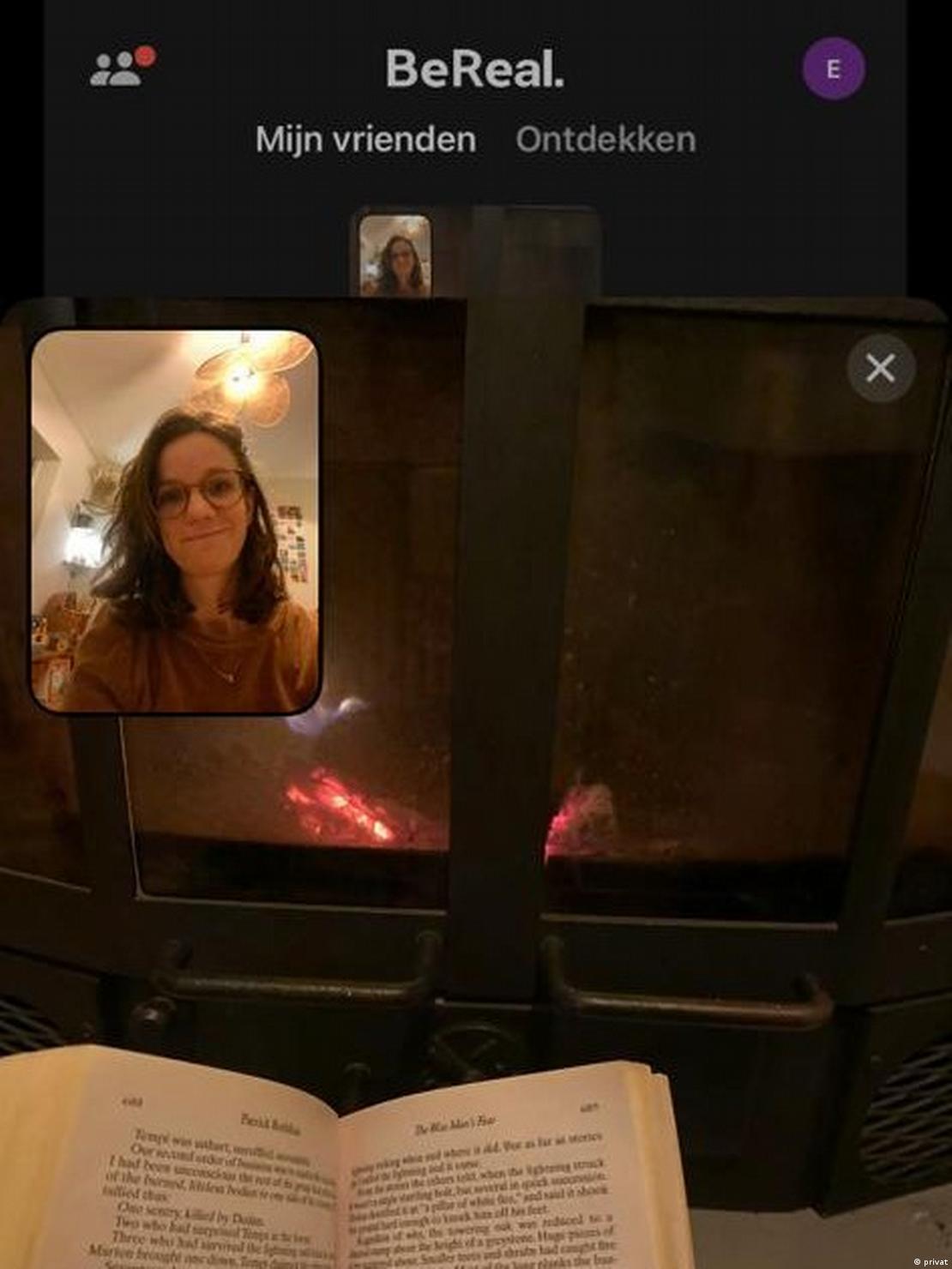 Snapshot  Captured by BeReal, showing a wood heater and a book and a selfie on the upper left corner.