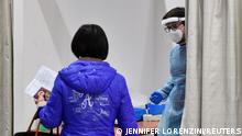 A health worker wearing personal protective equipment (PPE) waits for a passenger inside a cabin for coronavirus disease (COVID-19) tests, after Italy has ordered COVID-19 antigen swabs and virus sequencing for all travellers coming from China, where cases are surging, at the Malpensa Airport in Milan, Italy, December 29, 2022. REUTERS/Jennifer Lorenzini