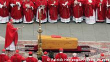 German Cardinal Joseph Ratzinger blesses the coffin of Pope John Paul II during his funeral mass in St Peter's Square at the Vatican City 08 April 2005. The world looked on Rome as leaders from more than 100 nations and a multitude of mourners gathered for the funeral Friday of Pope John Paul II, one of the most cherished pontiffs in history. (Photo credit should read PATRICK HERTZOG/AFP via Getty Images)