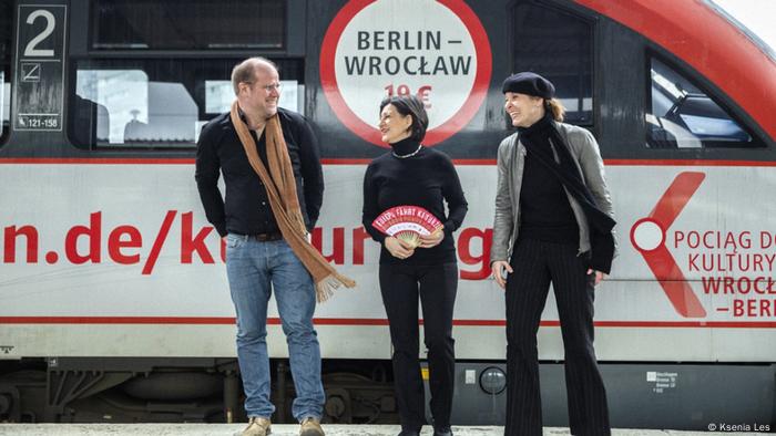 Vor der Jungfernfahrt des Kulturzugs: Oliver Spatz (Projektleiter), Ewa Strozczynska-Wille und Natalie Wasserman stehen im Bahnhof Berlin Lichtenberg vor dem Kulturzug