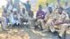A group of men sitting around a tree A group of men sitting around a tree