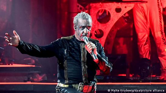 Rammstein's frontman, Till Lindemann, performing on stage with silver make up.