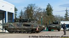 Ein Schützenpanzer der Bundeswehr vom Typ Puma wird auf einem Kasernengelände aus einer Halle gefahren.