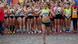 Runner Gesa Krause waves her hands while running with fellow runners applauding behind her