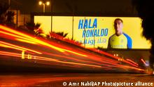 In this photo made with a slow shutter speed, a vehicle passes under a billboard showing Cristiano Ronaldo with Arabic wording which reads, Welcome Ronaldo, in Riyadh, Saudi Arabia, late Monday, Jan 2, 2023. Ronaldo completed a lucrative move to Saudi Arabian club Al Nassr on Friday in a deal that is a landmark moment for Middle Eastern soccer but will see one of Europe's biggest stars disappear from the sport's elite stage. (AP Photo/Amr Nabil)