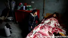 Liao Xiaofeng, 47, sits by an oxygen concentrator and her mother Chen Lifen, 86, upon returning from a clinic, at their home in a village of Lezhi county after strict measures to curb the coronavirus disease (COVID-19) were removed nationwide, in Ziyang, Sichuan province, China December 29, 2022. REUTERS/Tingshu Wang TPX IMAGES OF THE DAY 
