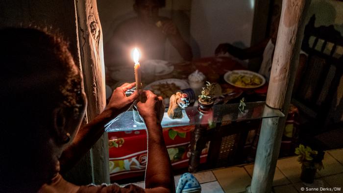 Tania Borges Sánchez enciende una vela para iluminar la cena familiar.