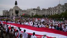 Demonstrators march as they hold a large flag during a march asking for peace, at plaza San Martin in Lima, Peru, Tuesday, Jan. 3, 2023. The march comes following the announcement to renew protests and road blocks against the government of President Dina Boluarte. (AP Photo/Martin Mejia)