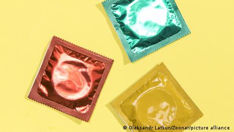 Drei Kondome in farblich unterschiedlichen Verpackungen