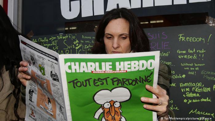 Una mujer lee la revista satírica Charlie Hebdo. (2015).