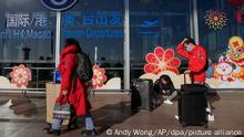 01.01.2023, China, Peking: Reisende mit Mund-Nasen-Schutz rollen Gepäck am internationalen Abflugterminal am Hauptstadtflughafen. Angesichts der aktuellen Corona-Infektionswelle in China führen immer mehr Länder die Testpflicht für Reisende aus dem Land ein. Foto: Andy Wong/AP/dpa +++ dpa-Bildfunk +++