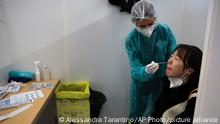 FILE - A passenger arriving from China is tested for COVID-19 at the Roissy Charles de Gaulle airport, north of Paris, Sunday, Jan. 1, 2023. European Union nations are fine-tuning a coordinated response to China's COVID-19 crisis on Wednesday, Jan. 4, 2023 and are zeroing in on travel restrictions that would upset both Beijing and the global airline industry. (AP Photo/Aurelien Morissard, File)