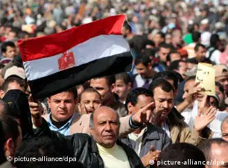 A protestor waves the Egyptian national flag during a protest in Tahrir Square