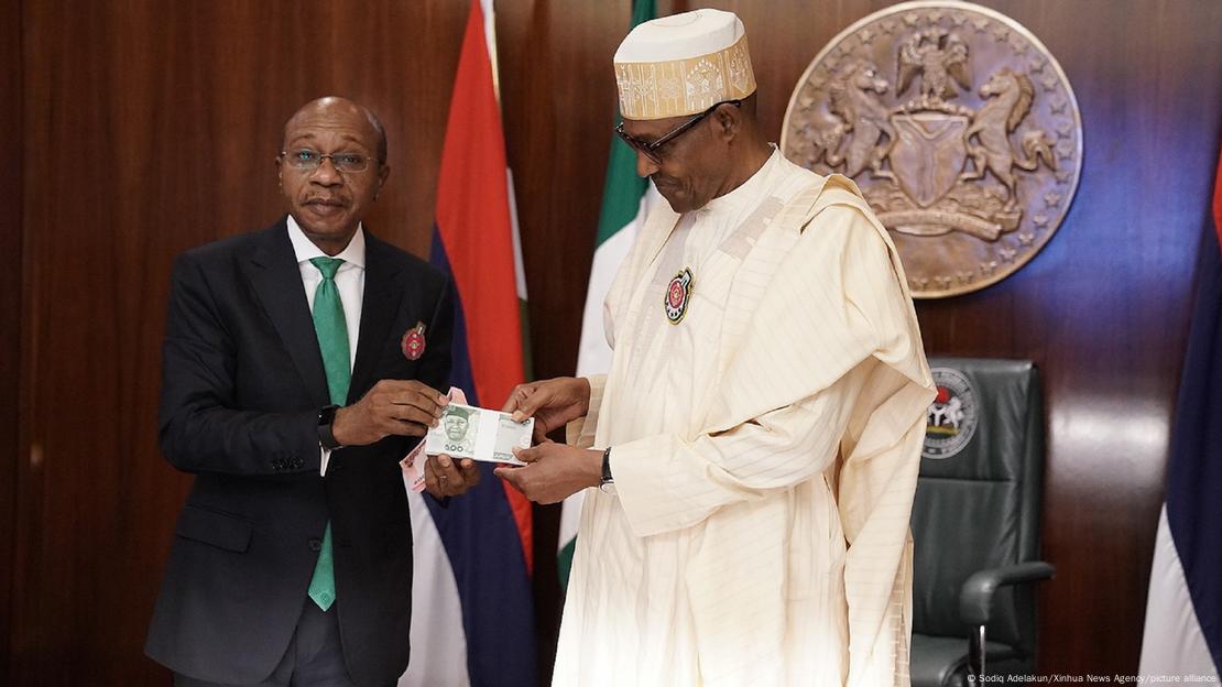 Nigerian President Muhammadu Buhari and Godwin Emefiele, the governor of the Central Bank of Nigeria, present the redesigned banknotes of Nigerian naira