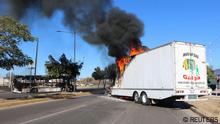 The burnt wreckage of a bus and a burning truck, set on fire by members of a drug gang are pictured following the detention of Mexican drug gang leader Ovidio Guzman, a son of incarcerated kingpin Joaquin El Chapo Guzman, who has been arrested by Mexican authorities, in Culiacan, Mexico, January 5, 2023. REUTERS/Stringer