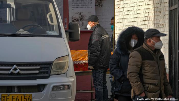 Corpo de vítima de covid-19 é carregado para fora de hospital de Pequim. Recrudescimento do coronavírus preocupa autoridades chinesas