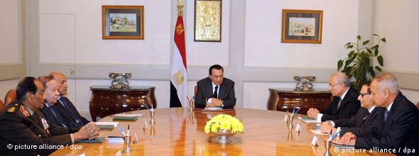 Mubarak sitzt mit mehreren Mitgliedern der Regierung an einem großen ovalen Tisch (Foto: dpa)