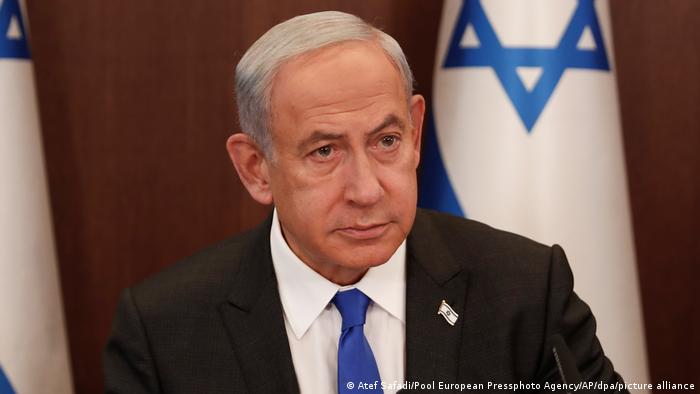 Ministerpräsident Benjamin Netanjahu schaut ernst vor israelischer Flagge