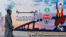 People pass by a billboard announcing Arab Gulf Cup in Basra, Tuesday, Jan. 3, 2023. The 25th edition of the Arabian Gulf Cup will be held in the city of Basra, the first time the turmoil-wracked country will host the tournament since 1979. (AP Photo/Nabil al-Jurani)i)