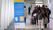 2023-01-04 15:27:01 SCHIPHOL  Reisende aus China gehen an einem Informationsbanner vorbei und erhalten bei der Ankunft auf Schiphol einen kostenlosen Corona-Selbsttest. Die Selbsttests sind mit Hinweisen zur Verwendung in Mandarin oder Kantonesisch versehen. ANP ROBIN VAN LONKHUIJSEN