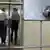 Ein Justizvollzugsbeamter verschließt eine Gittertür Gefängnis, während ein Häftling von einem weiteren Beamten begleitet wird (Quelle: dpa)