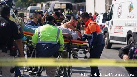 Un pasajero herido es trasladado en camilla a una ambulancia frente a la estación de La Raza, en Ciudad de México.
