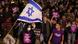 Protesters in Tel Aviv hold up the Israeli flag and various protest posters Protesters in Tel Aviv hold up the Israeli flag and various protest posters