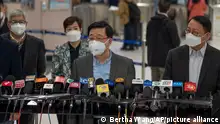Hong Kong Chief Executive John Lee, center, wearing a face mask speaks to the media after he inspected Lok Ma Chau station following the reopening of crossing border with mainland China, in Hong Kong, Sunday, Jan. 8, 2023. Travelers crossing between Hong Kong and mainland China, however, are still required to show a negative COVID-19 test taken within the last 48 hours, a measure China has protested when imposed by other countries. (AP Photo/Bertha Wang)