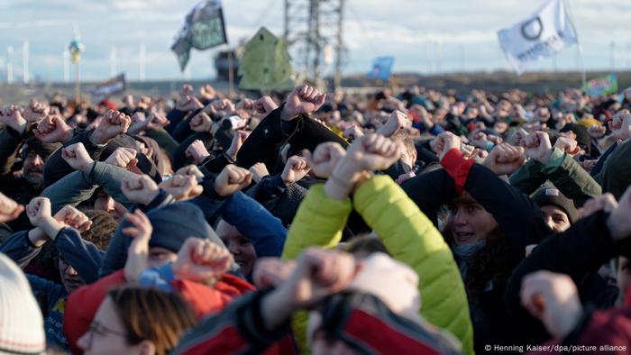 Los participantes en una concentración al borde de la mina a cielo abierto cerca de Lützerath cruzan los brazos en señal de resistencia. 