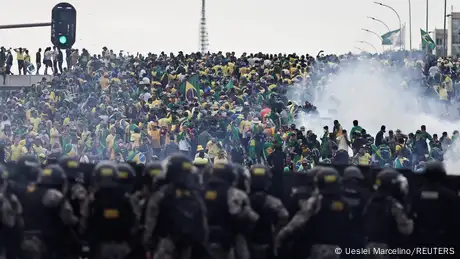 Police officers try to stop a crowd of protesters