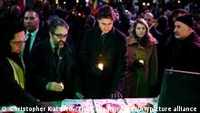 Canadian Prime Minister Justin Trudeau, center, Minister of Foreign Affairs Melanie Joly and Iranian activist Hamed Esmaeilion place candles on a memorial during a vigil marking the three year anniversary of the downing of flight PS752 in Toronto on Sunday, Jan. 8, 2023. (Christopher Katsarov/The Canadian Press via AP)