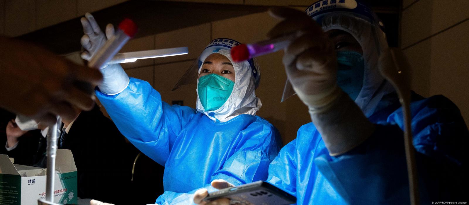 Medical workers dressed in protective gear get ready to perform PCR tests in Beijing