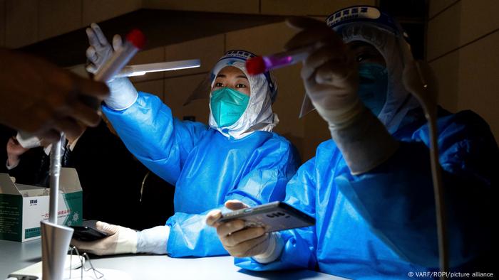 Dos personas trabajan en un laboratorio de China realizando test PCR de covid.