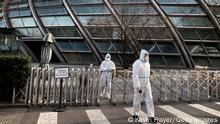 BEIJING, CHINA - DECEMBER 11: Security wear PPE to protect against the spread of COVID-19 as they guard outside an office building on December 11, 2022 in Beijing, China. As part of a 10 point directive, Chinas government announced Wednesday that people with COVID-19 who have mild or no symptoms will be permitted to quarantine at home instead of at a government facility, testings requirements are reduced, people are permitted to buy over the counter medications, and local officials can no longer lock down entire neighbourhoods or cities, a major shift in its zero COVID policy. (Photo by Kevin Frayer/Getty Images)