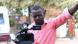 A cameraman at work in the streets of Kampala, Uganda