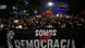Pessoas atrás de uma faixa que diz: Somos pela Democracia Pessoas atrás de uma faixa que diz: Somos pela Democracia