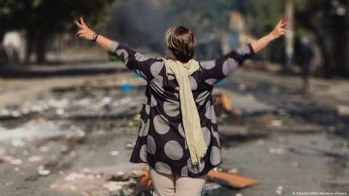 Γυναίκα χωρίς μαντίλα περπατάει με τα χεριά τεντωμένα στους δρόμους της Τεχεράνης