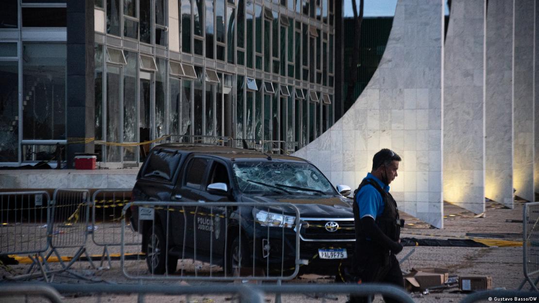 Un agente pasa junto a un edificio gubernamental con los cristales de las ventanas rotos el 9 de enero de 2023, un día después del intento de golpe.