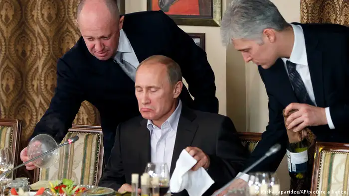 2011年，普里戈津（左）在一次晚宴上为时任俄罗斯总理的普京服务。