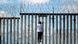 A man climbing a border fence A man climbing a border fence