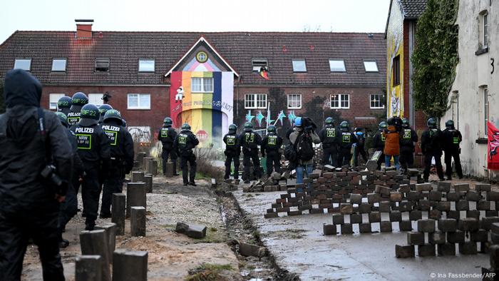 Policías delante de casa a desalojar en Lützerath, Renania del Norte-Westfalia.