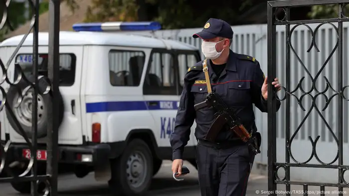 September, 2020: A police officer closes the gates outside the Directorate of Internal Affairs for Oktyabrsky District, where detained journalists covering an unauthorized protest are kept