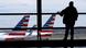 A man looks at the airplanes through the airport window in Washington DC A man looks at the airplanes through the airport window in Washington DC