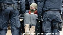 Police officers carry away a protestor at the village Luetzerath near Erkelenz, Germany, Thursday, Jan. 12, 2023. Police have entered the condemned village in to evict the climate activists holed up at the site in an effort to prevent its demolition, to make way for the expansion of a coal mine.(AP Photo/Michael Probst)